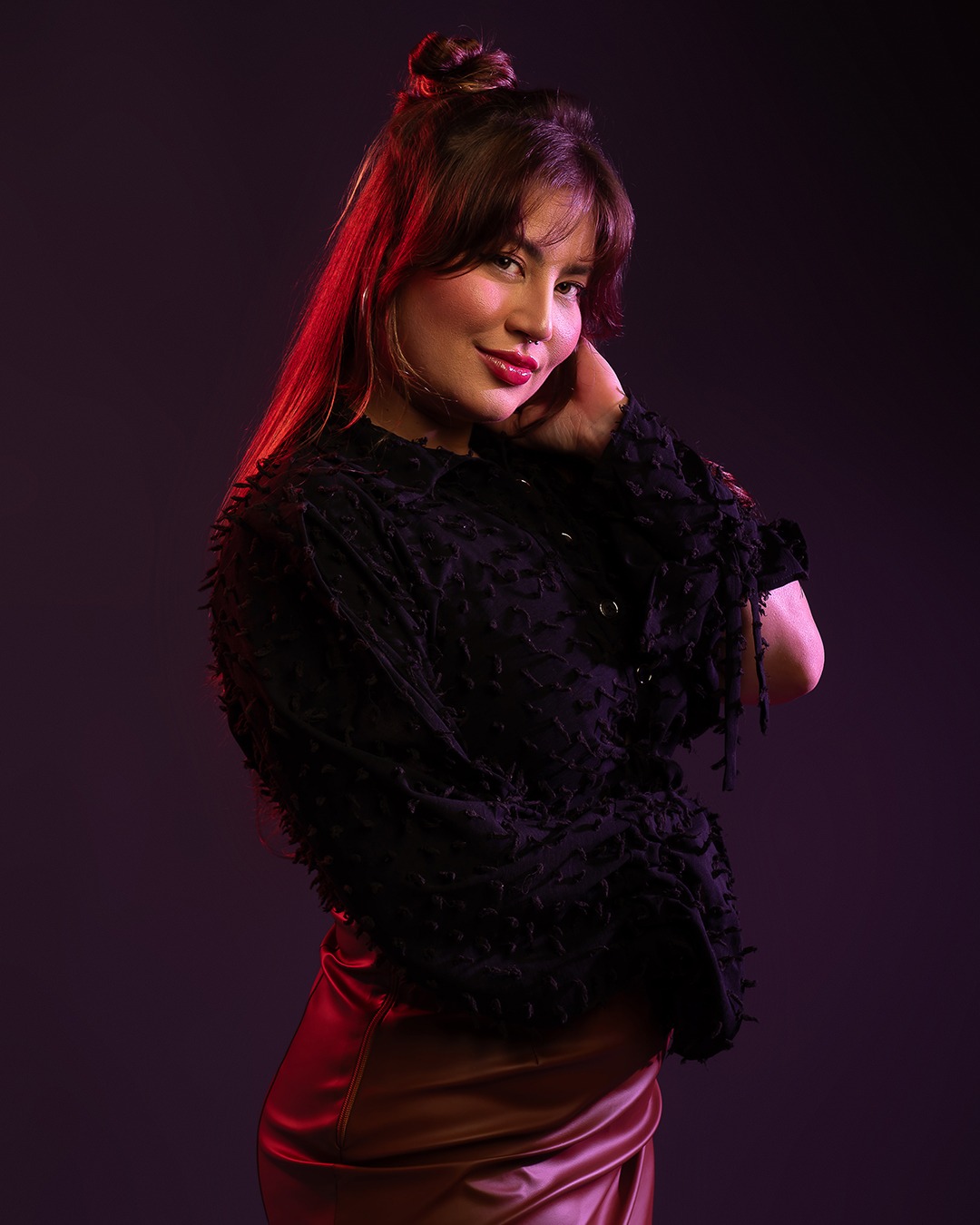 Bruna Pires em retrato artístico, com blusa preta e iluminação suave